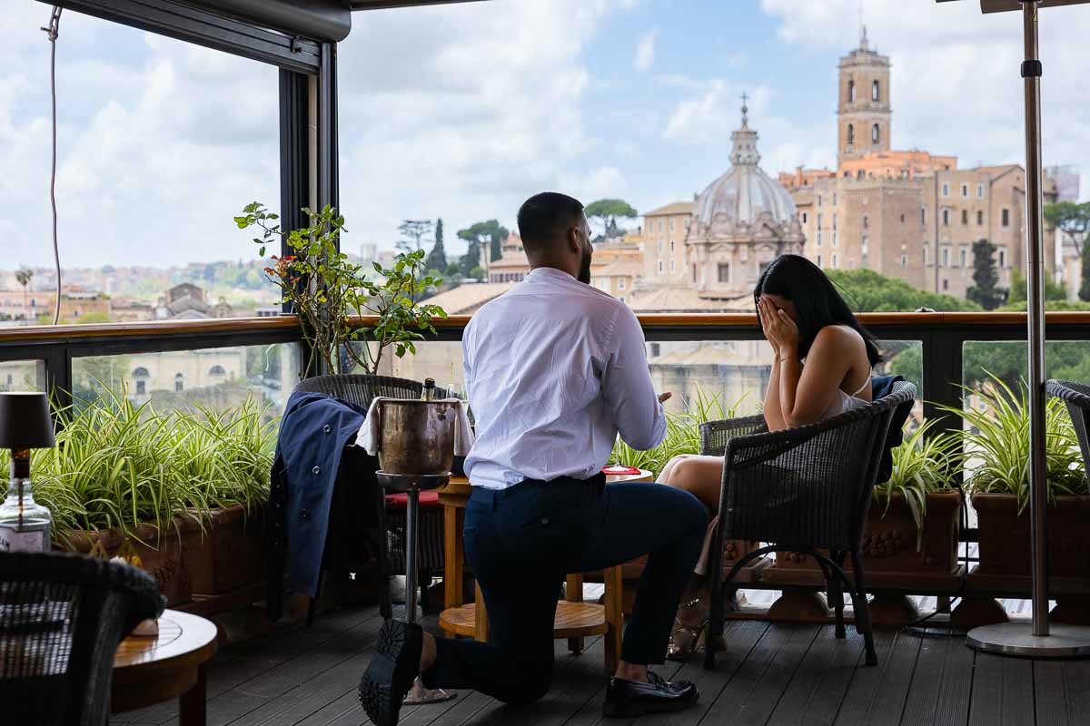 Man knee down wedding marriage proposal overlooking the city of Rome from afar on a terrace with a view