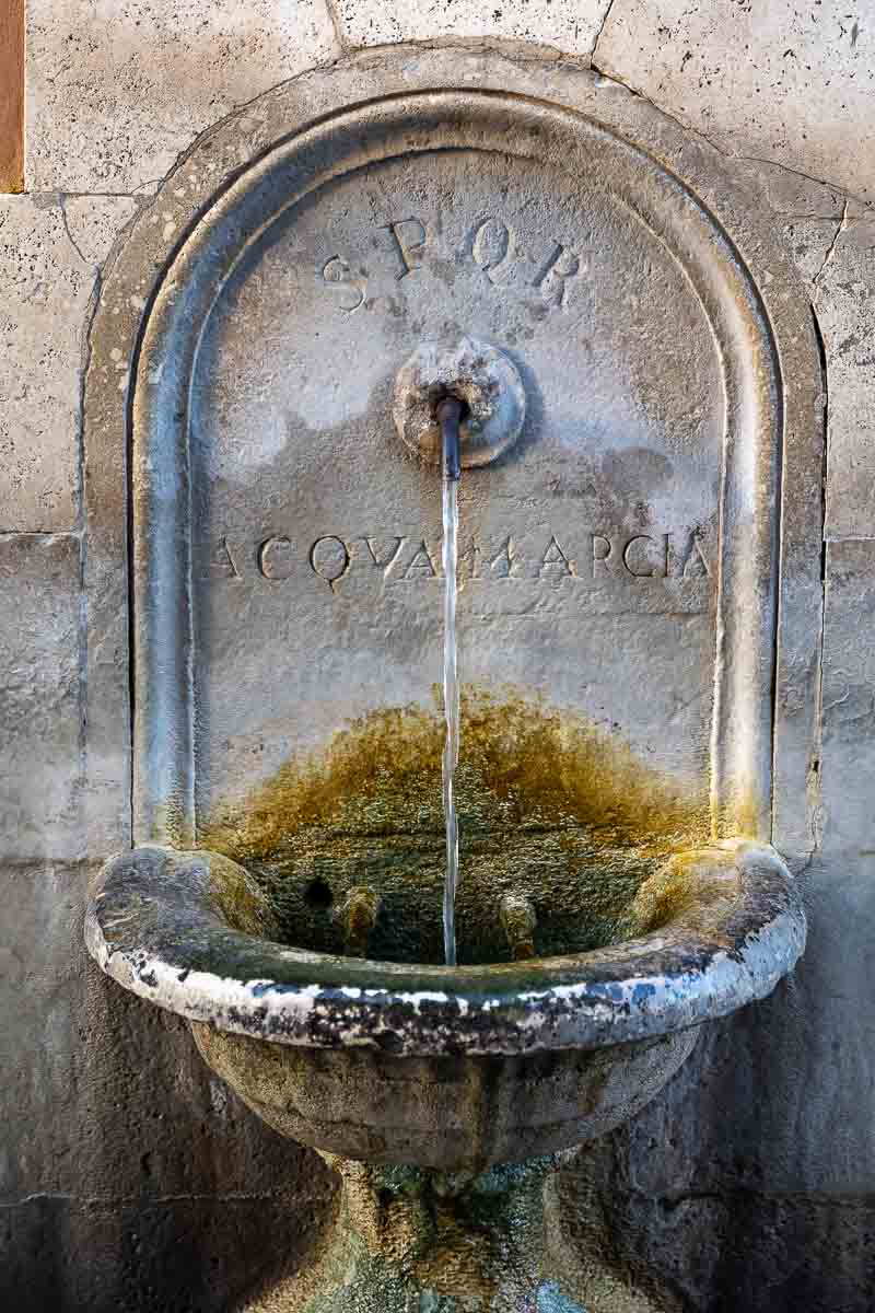 A typical roman marble water fountain with gushing water 