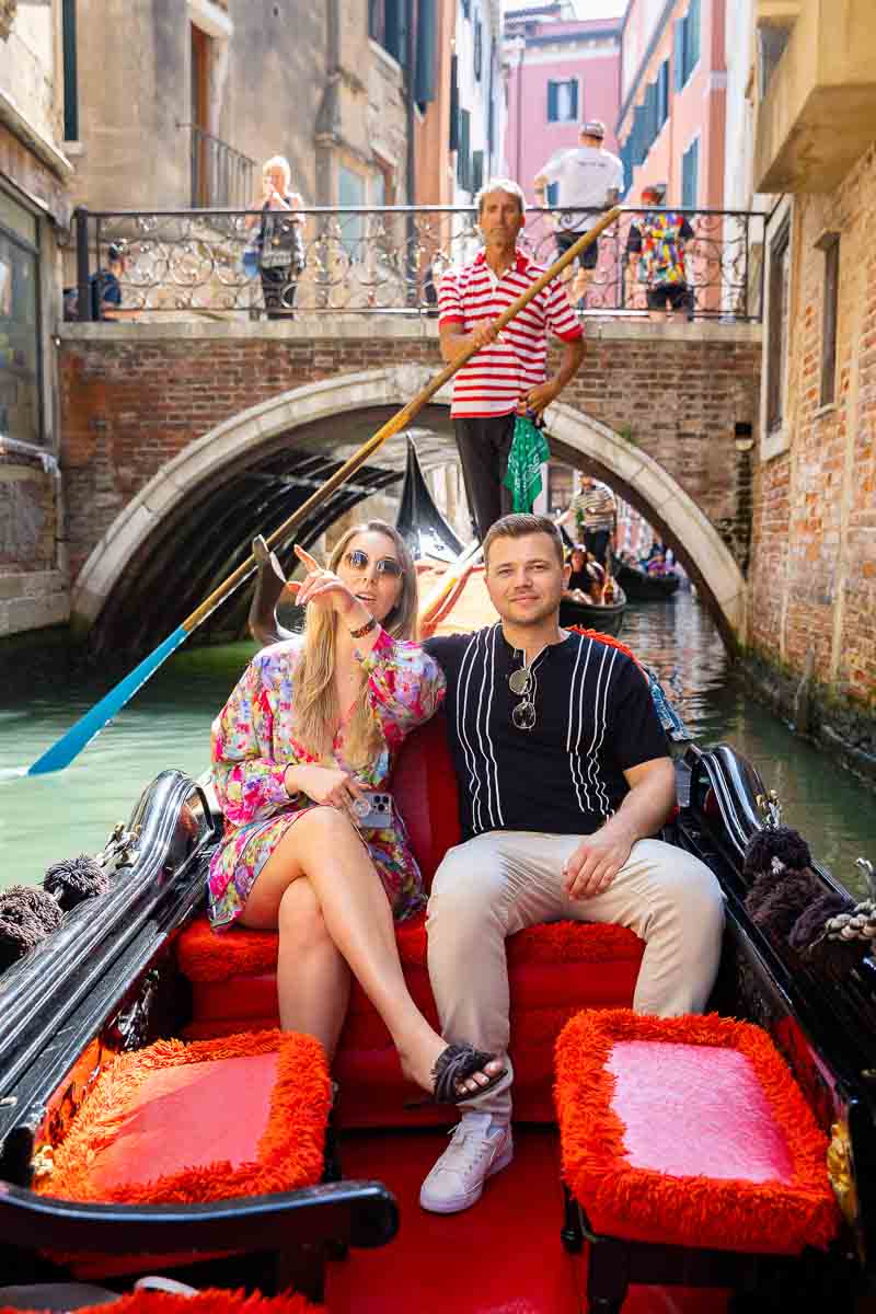 Couple enjoying a nice gondola ride through the small water canals of Venice Italy 