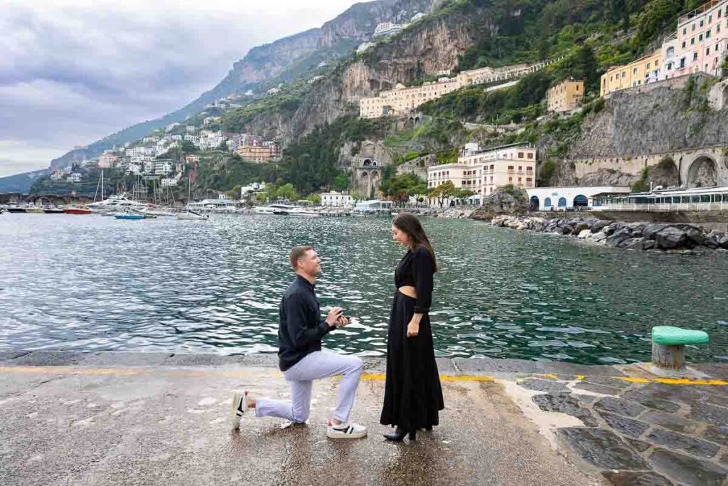 Proposing marriage on the coast of Amalfi with the water and the town in the background