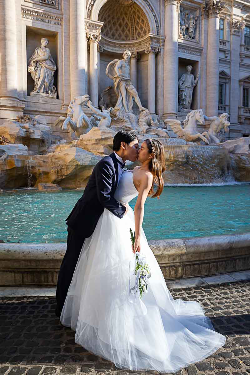 The dip pose. Portrait of the bride and groom shot while shooting a wedding couple at Rome's Trevi fountain