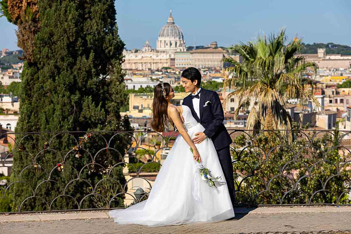 Couple posing in front of the Saint Peter's dome in the far distance 