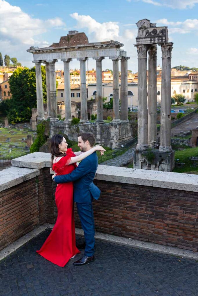 Side posed couple during a photoshoot in Rome Italy at Piazza del Campidoglio with an incredible view of the Roman forum as backdrop