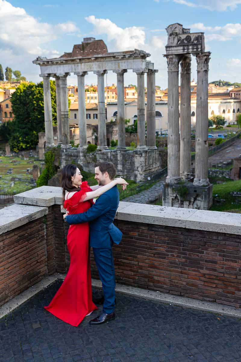 Side posed couple during a photoshoot in Rome Italy at Piazza del Campidoglio with an incredible view of the Roman forum as backdrop 