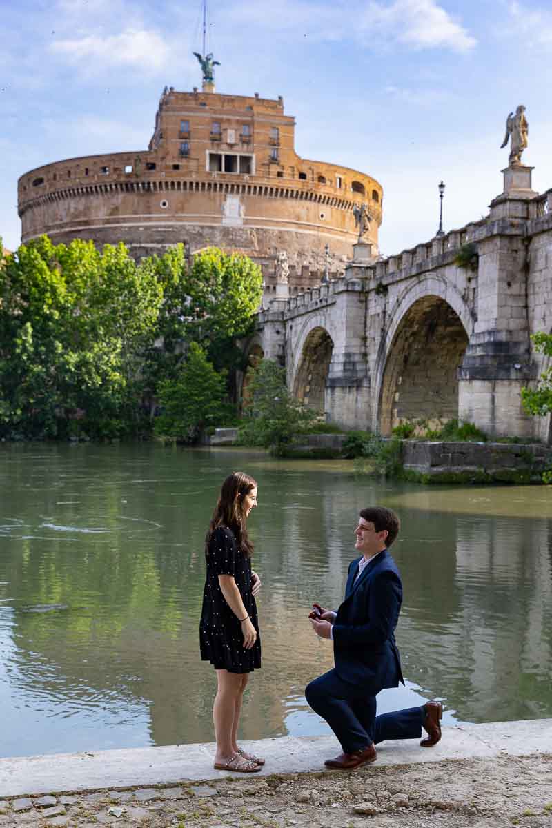 Knee down wedding marriage proposal asked by the Castel Sant'Angelo bridge in the early morning sunlight 