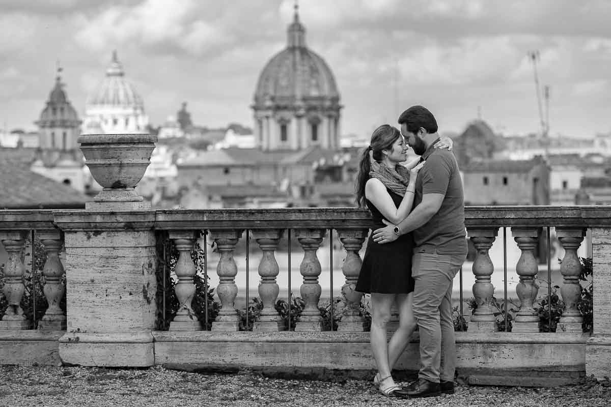 Black and white photography of a couple posing in front of the Roman cityscape during a photo session in Rome