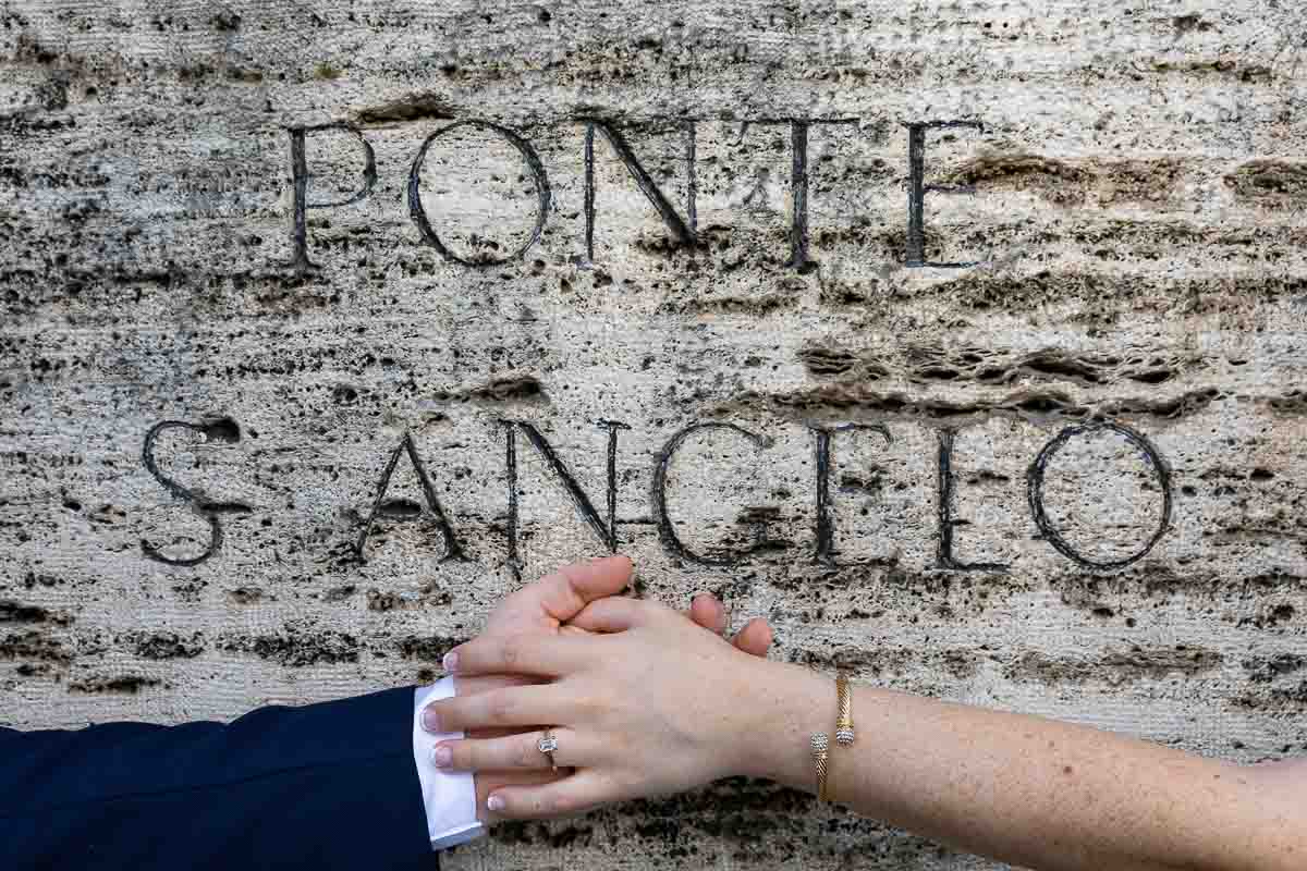 Picture of the engagement ring photographed over the castel sant'angelo ancient stone encryption 