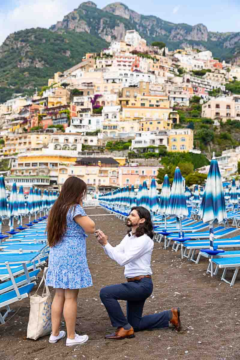 Knee down wedding Positano Beach Proposal on the Amalfi coast with the vertical town in the background 