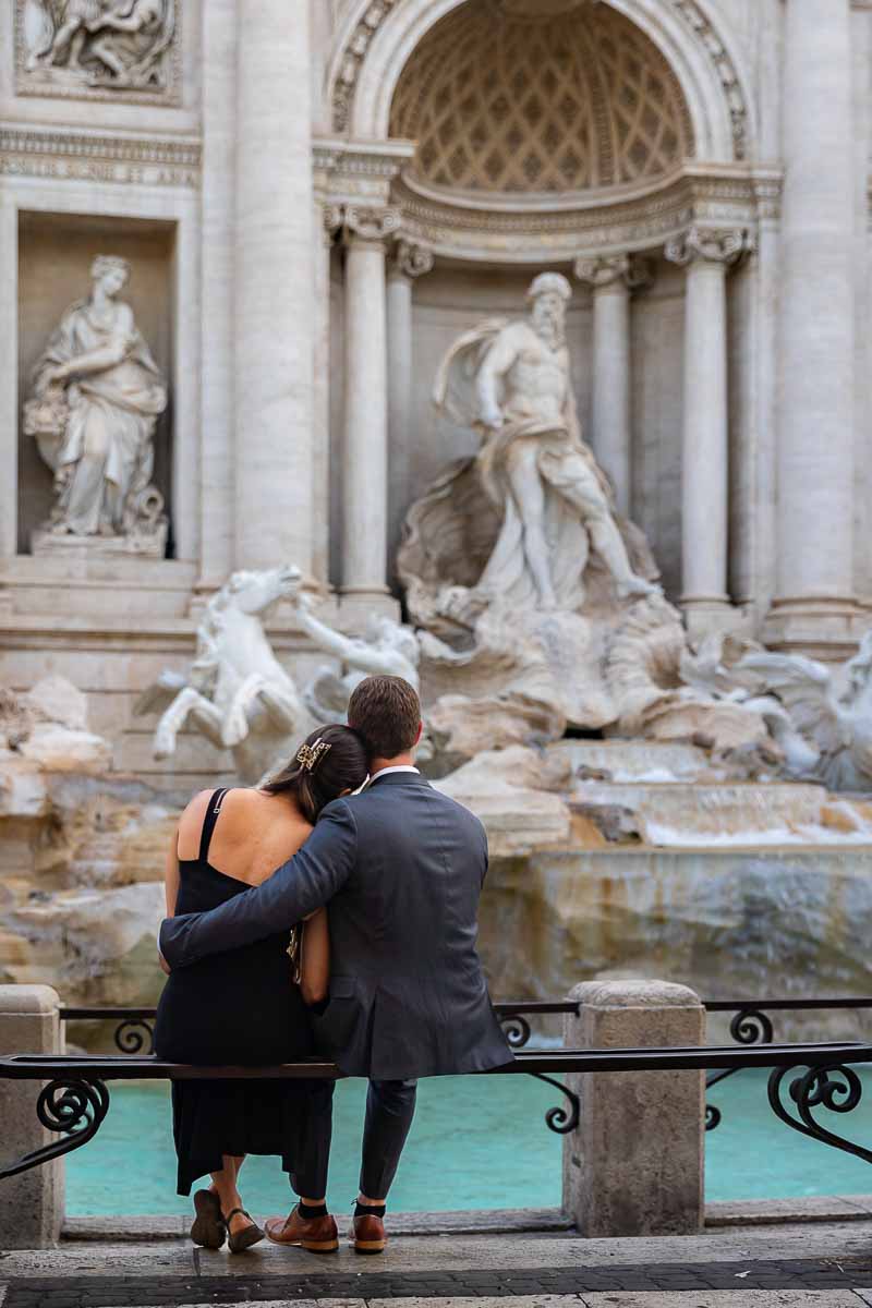 Sitting down looking and admiring the Trevi fountain from the metal railing 