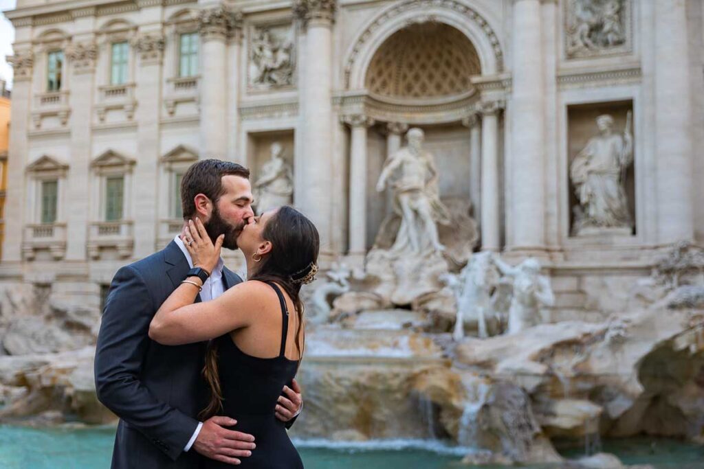Engagement couple kissing at Rome's Trevi fountain
