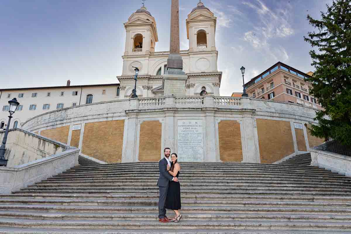 Standing on the steps of the Spanish steps with church Trinita' dei Monti in the background 