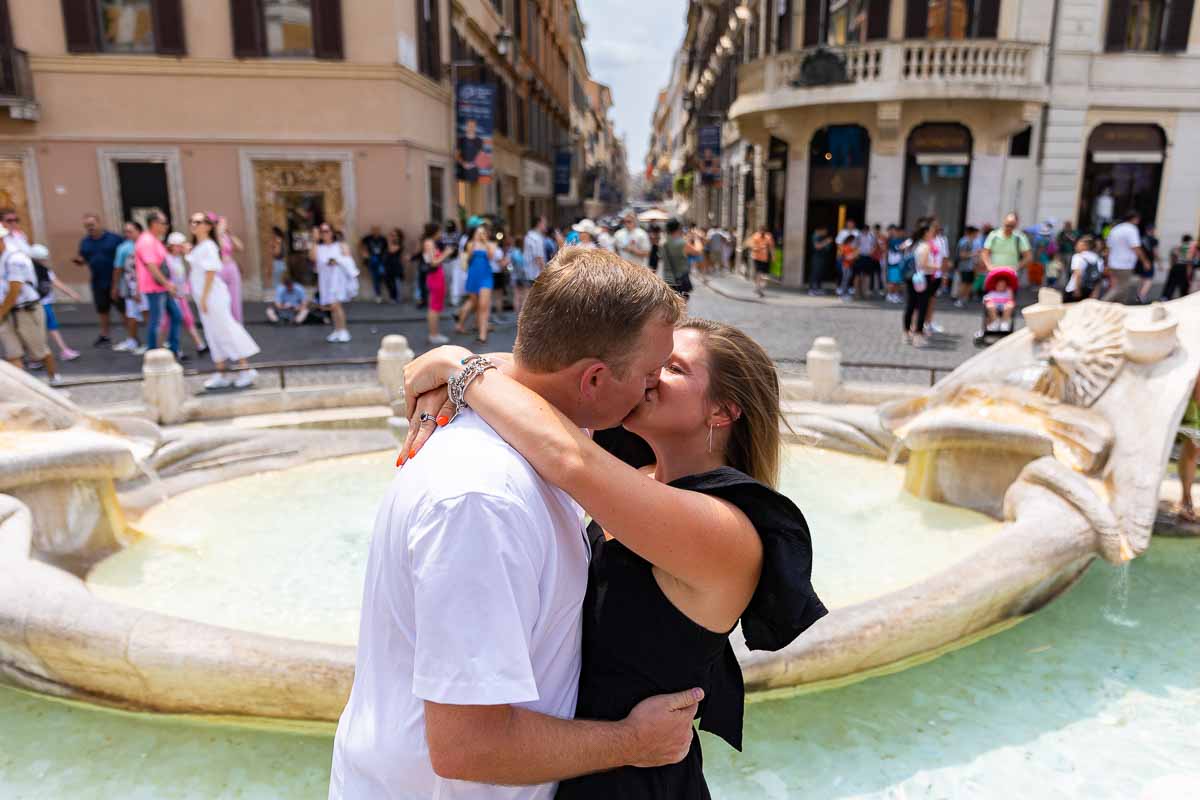 Kissing in front of the Barcaccia water fountain found at the bottom of Piazza di Spagna