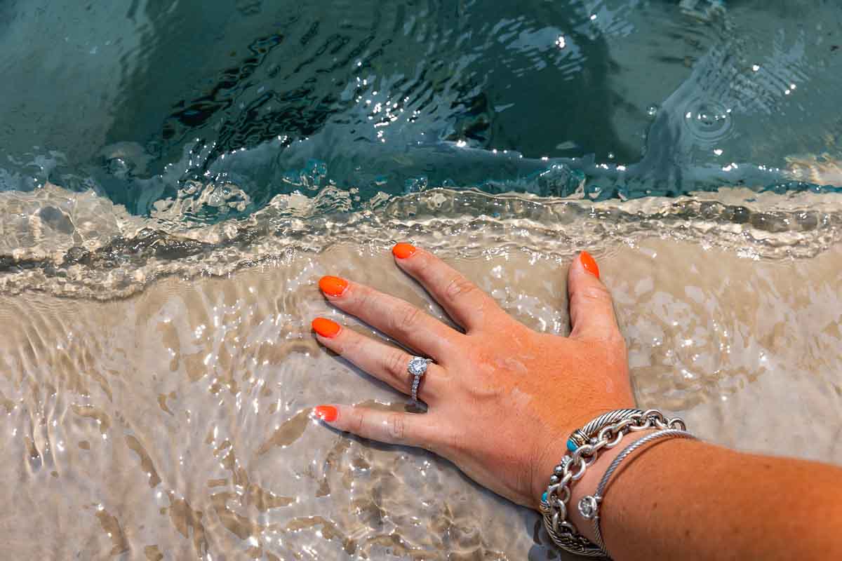 Engagement ring shot taken on the edge of the water fountain with the water splashin over it