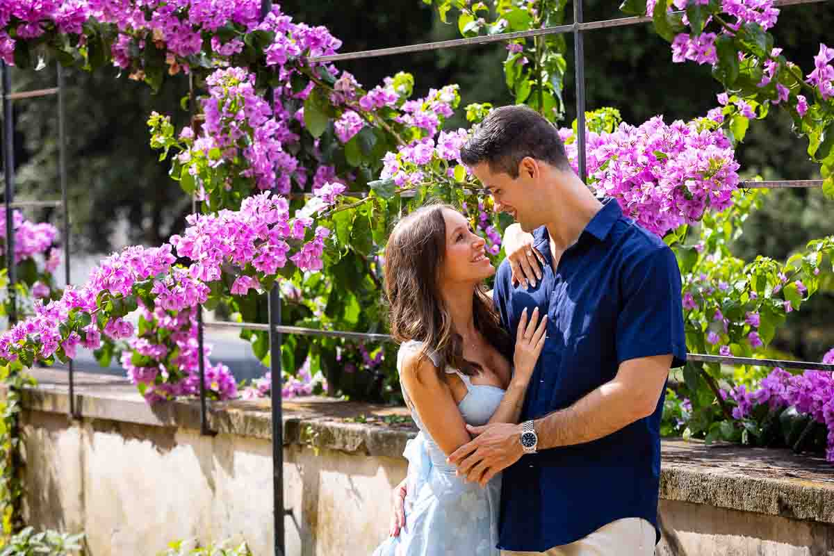 Colorful couple portrait picture taken in front of fuchsia bougainvillea flowers 