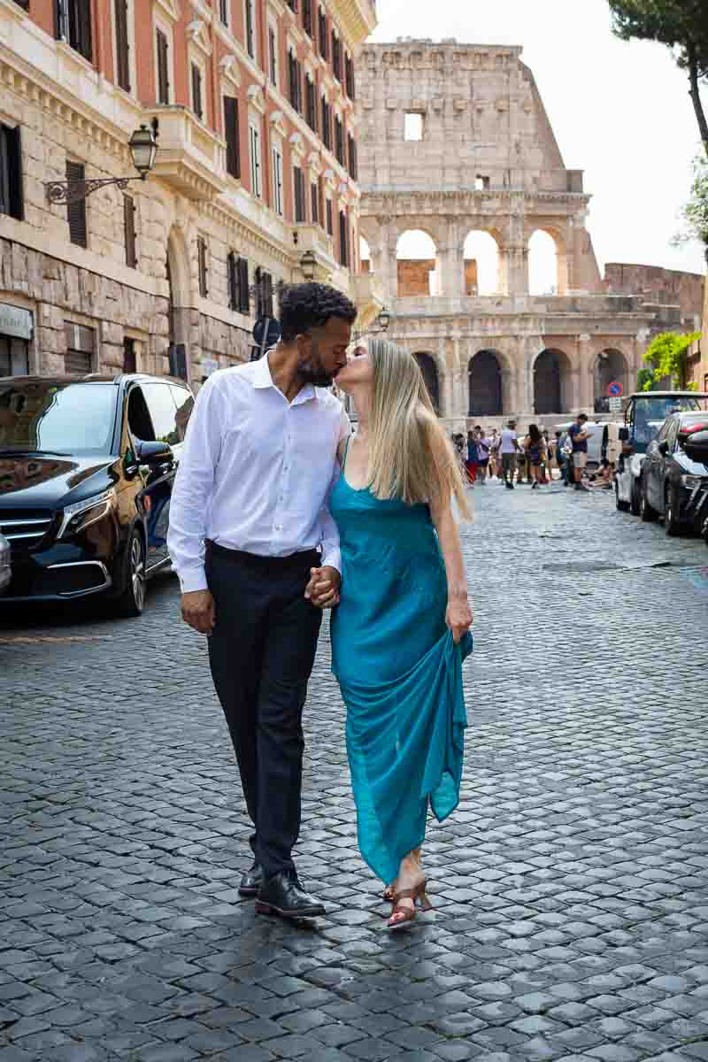 Walking in Rome during a photoshoot with the Colosseum in the background on a cobblestone alleyway 