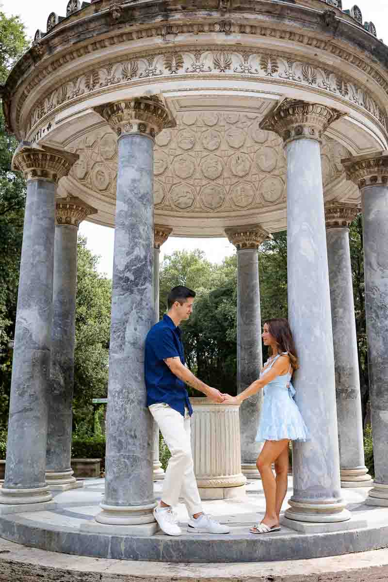 Standing by the Villa Borghese Temple of Diana in Rome Italy during a couple photoshoot after proposal