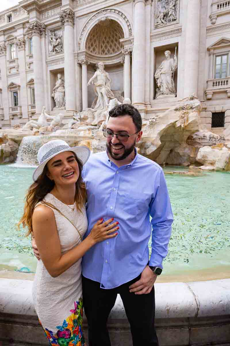Couple laughing and having fun at the Trevi fountain during a photo shoot 