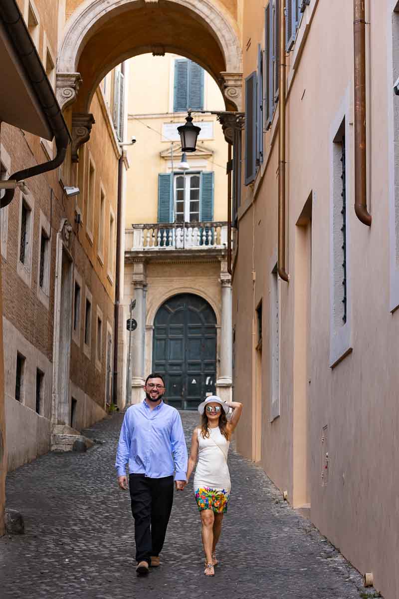 Walking in Rome hand in hand on cobblestone alleyways under ancient portico