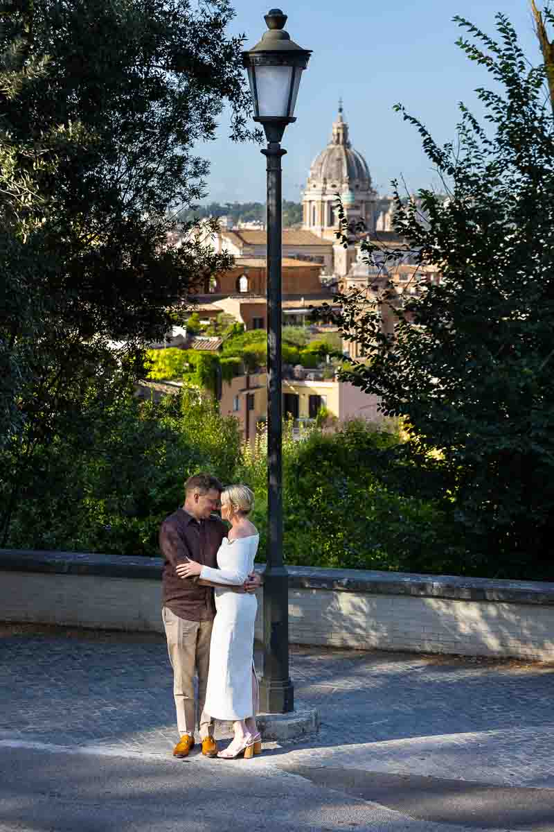 Standing underneath a street light before the beautiful roman skyline photographed in couple pictures 