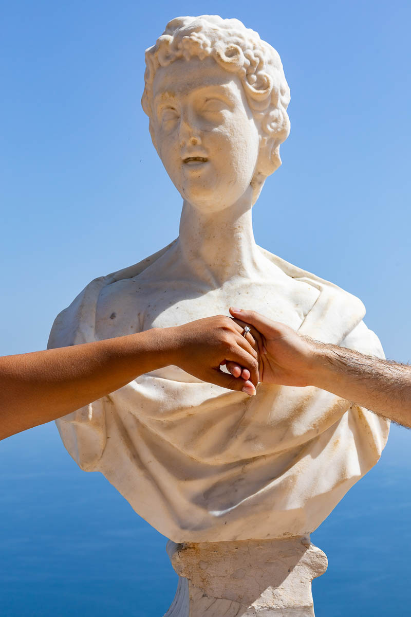 Engagement ring photography taken over white marble statue