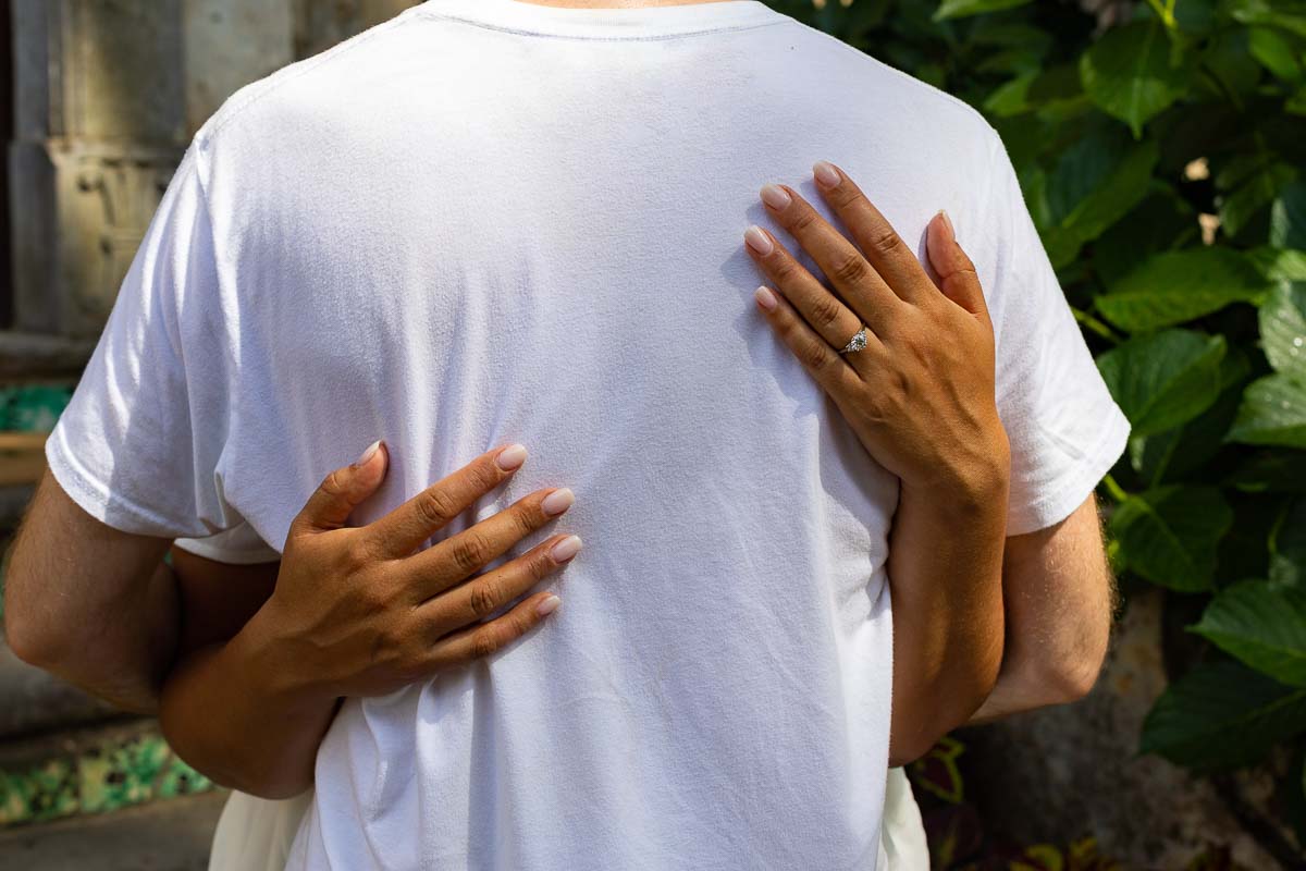 Engagement ring shot taken from the back on white shirt