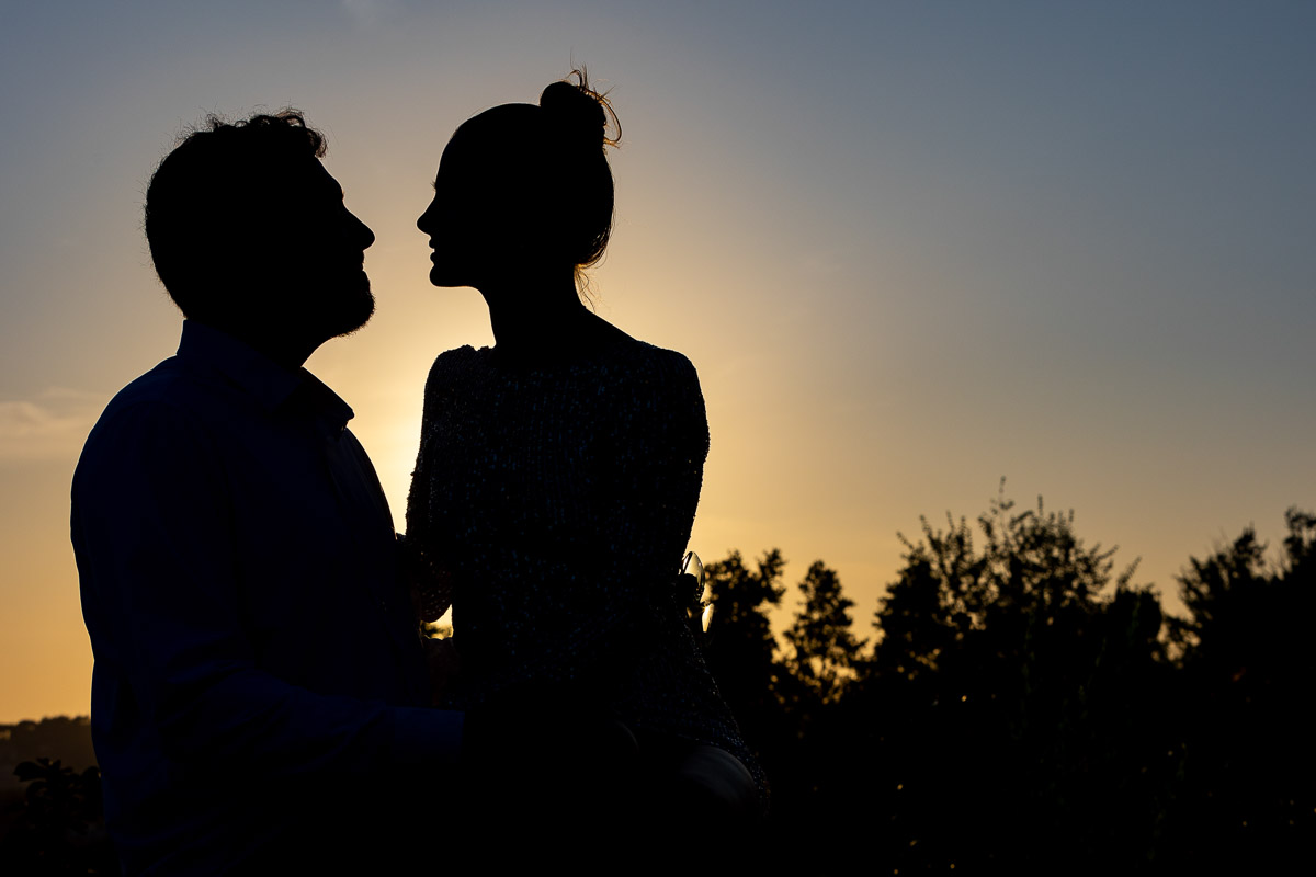 Silhouette image of a couple photographed against the sun at sunset
