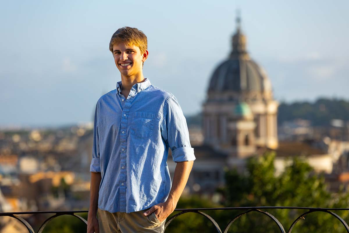 Male senior picture photography in Rome taken at the Pincio park terrace overlooking the roman skyline