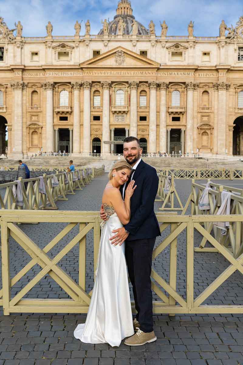 Wedding bride and groom posed in front of Saint Peter's basilica facade in Rome Italy 
