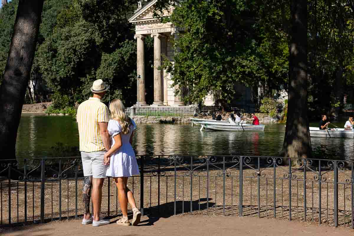 Looking together at the Temple of Aesculapius foundat the Villa Borghese lake in Rome Italy