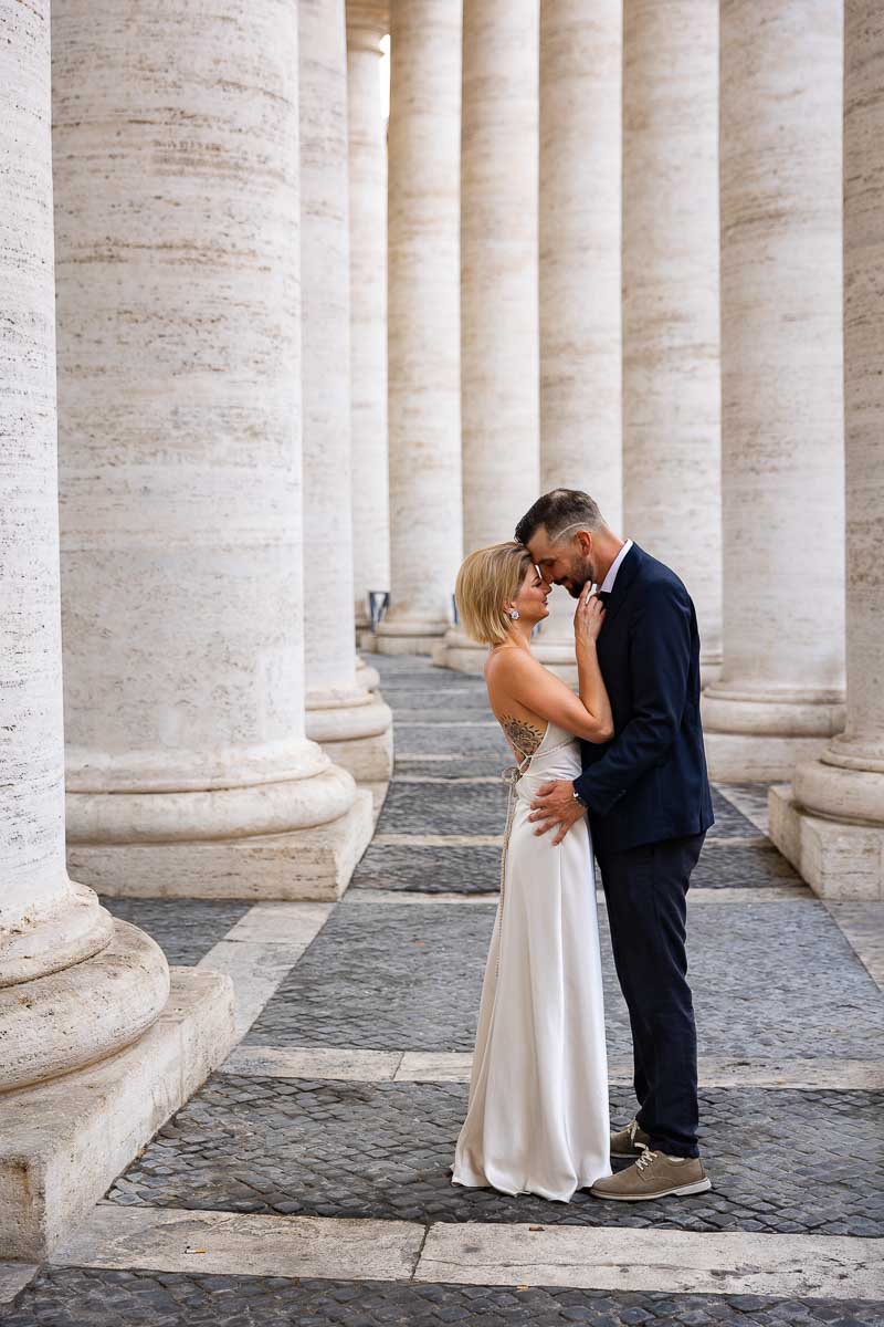 Posing wedding portrait couple under the Vatican's colonnade in St. Peter's square 