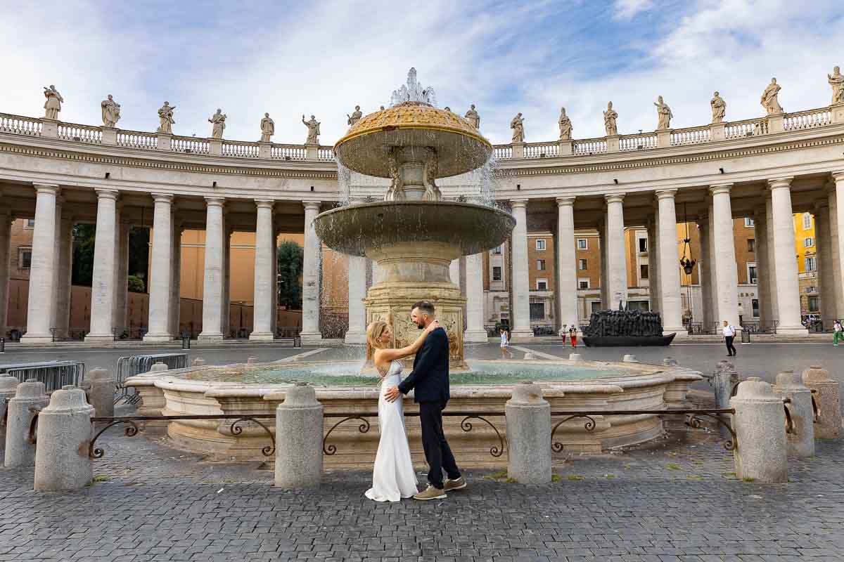 Taking wedding photos bby one of the main water fountain found in San Peter's square in Rome Italy