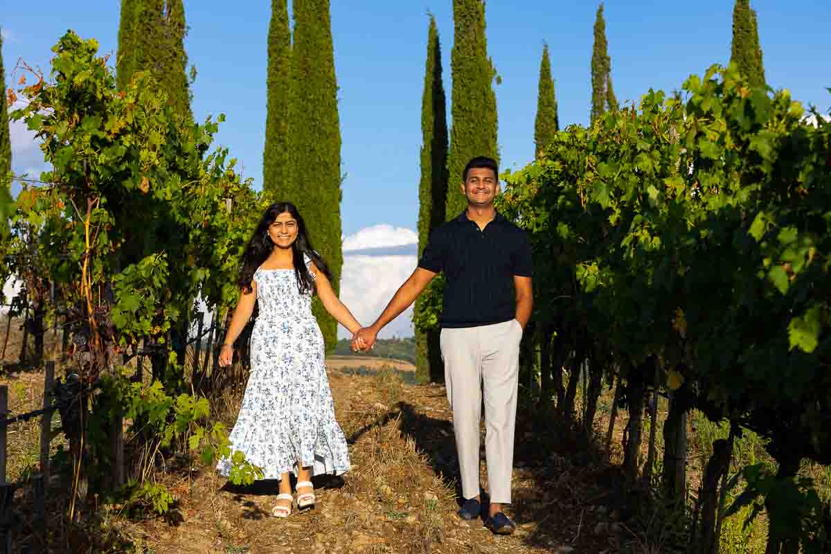 Walking hand in hand on a vineyard during an engagement photo session