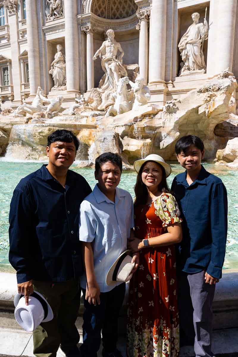 Posed family portrait photographed at the Trevi fountain during daytime 