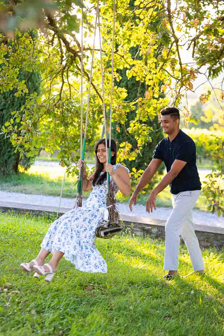 Couple pushing each other on a swing during a photographer session