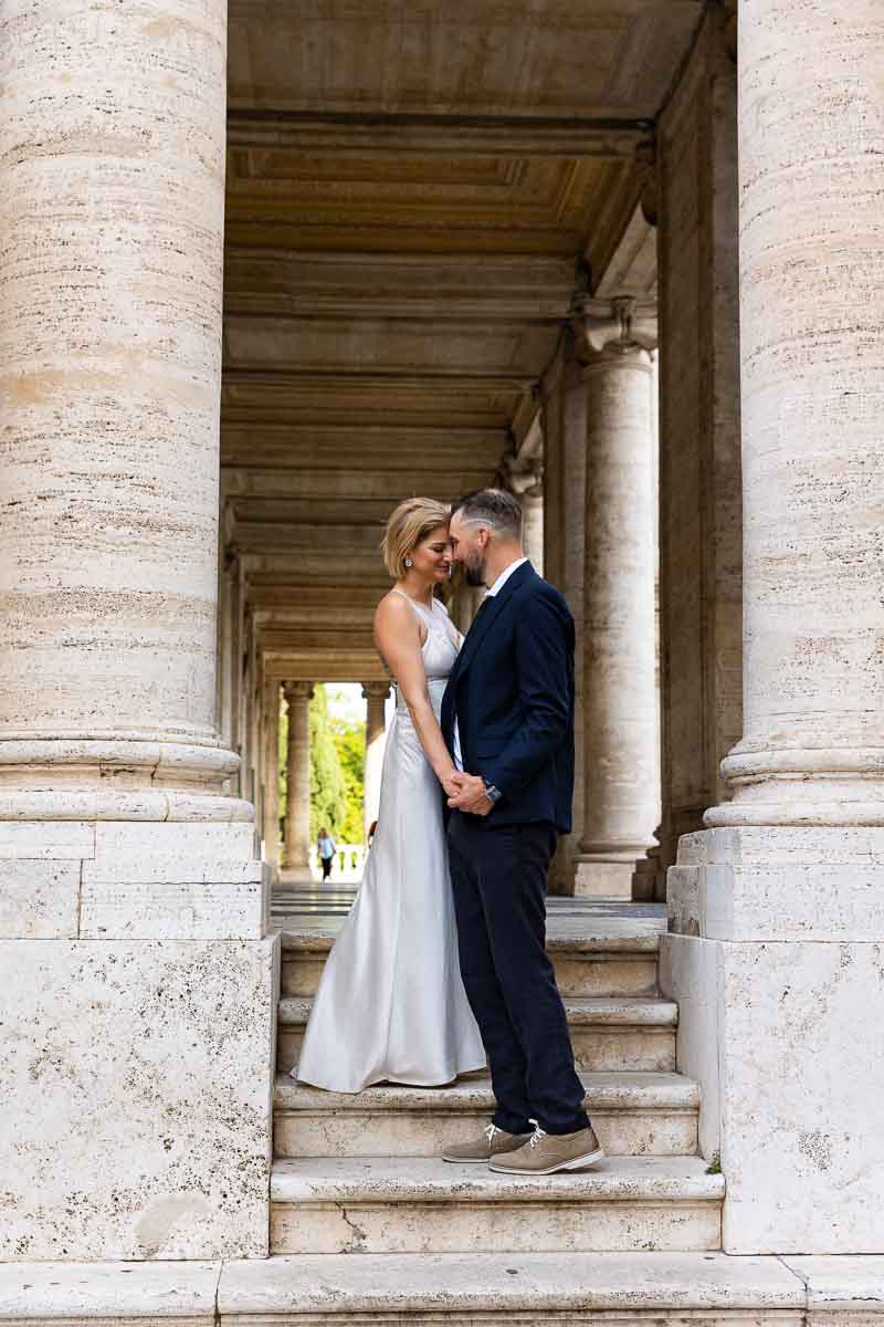 Portrait picture of a couple together under large Rome marble columns 