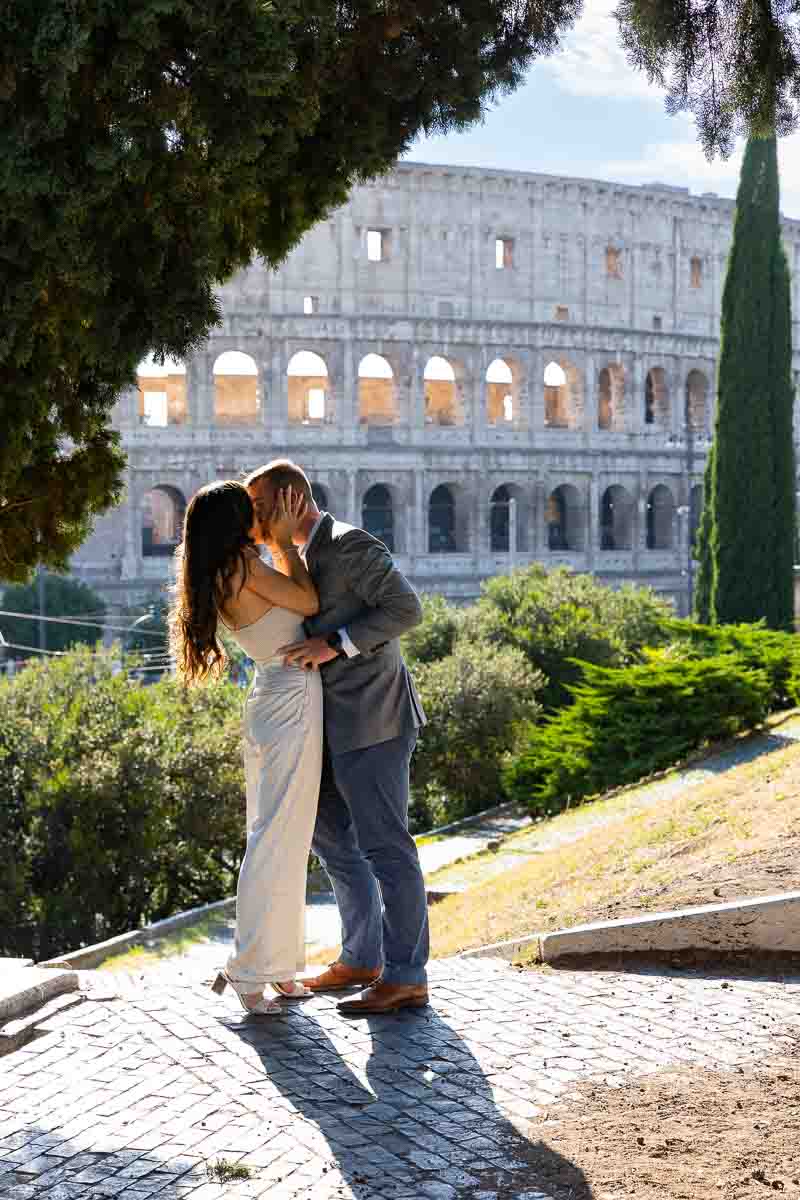 Couple kissing in front of the Colosseum during and engagement photoshoot in Rome Italy