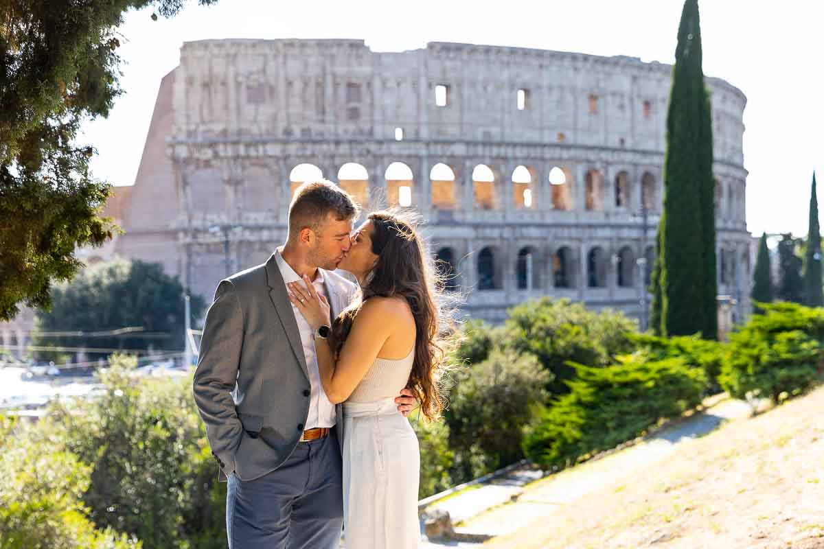 Kissing couple by the Colosseum during engagement photography in Rome