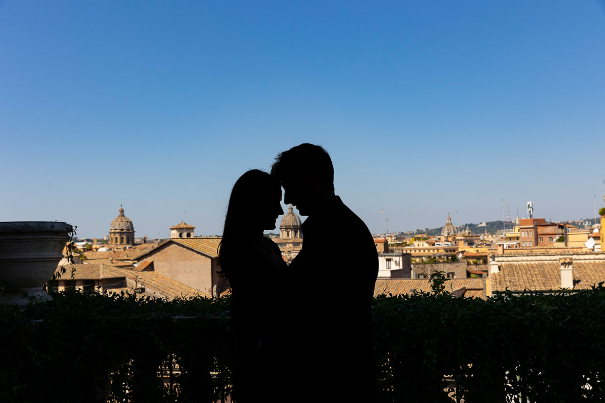 Silhouette couple shot against the sky with the roman skyline in the background 