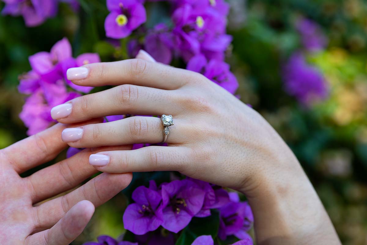 Image of the engagement ring photographed up close over fuchsia flowers 
