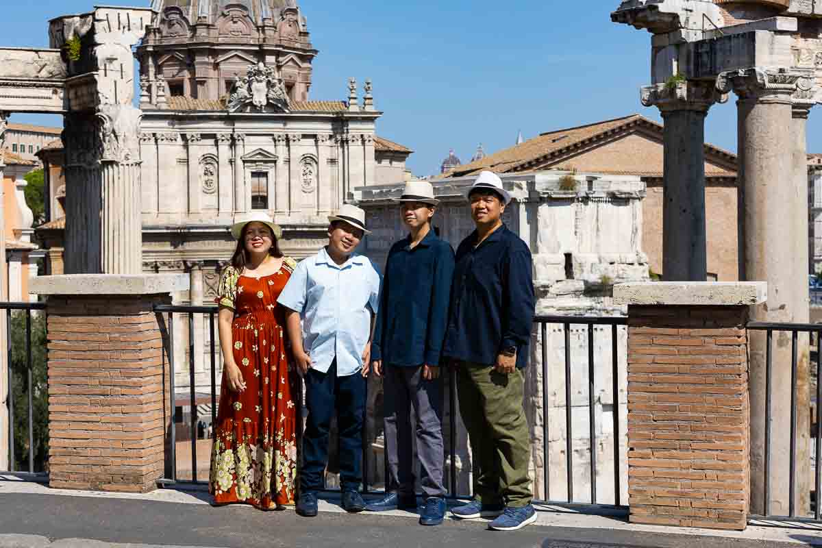 Family taking vacation pictures at the Roman Forum while visiting the Ethereal city of Rome Italy 