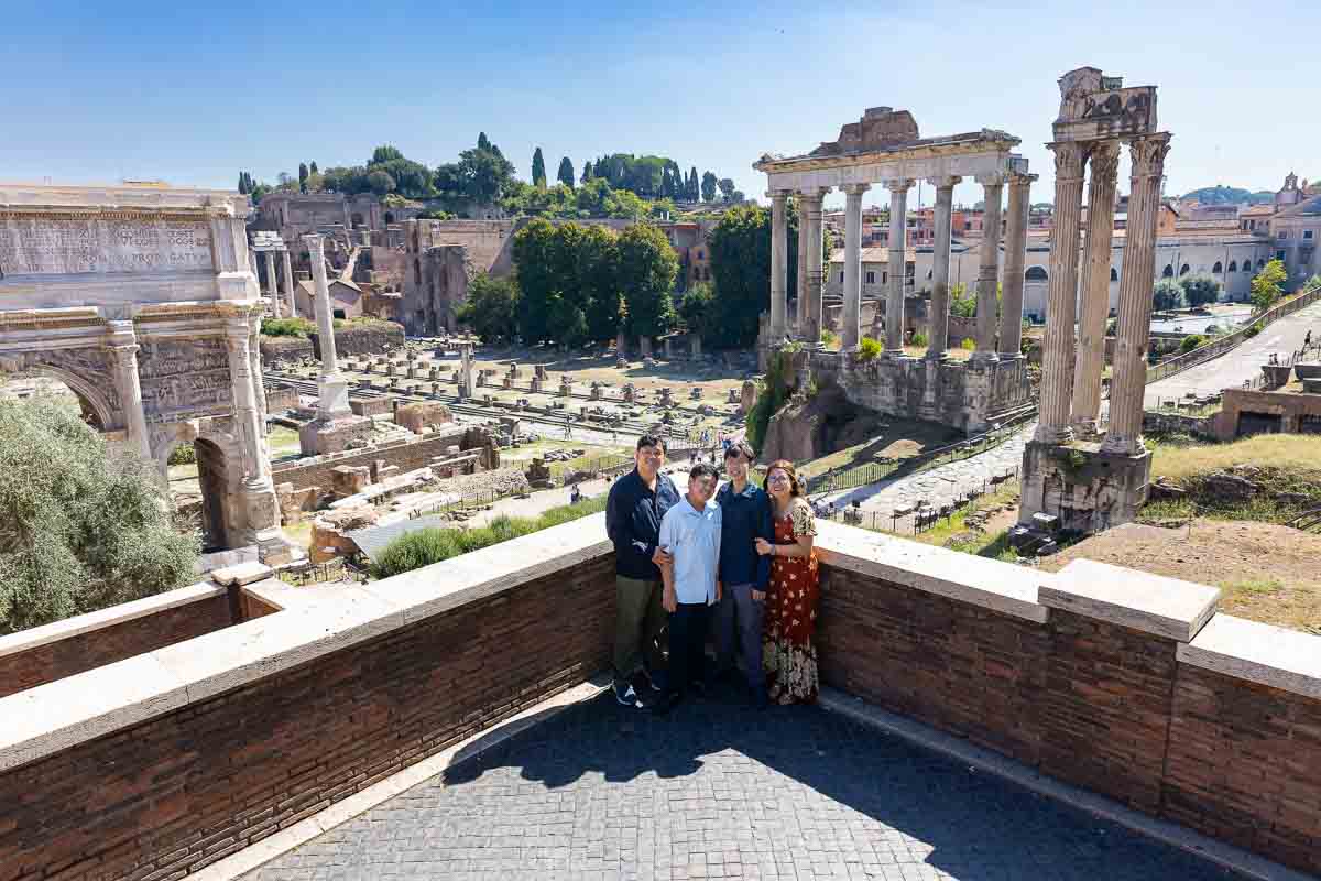 Wide angle view photography of a family posing during a vacation photoshoot at the Roman Forum 