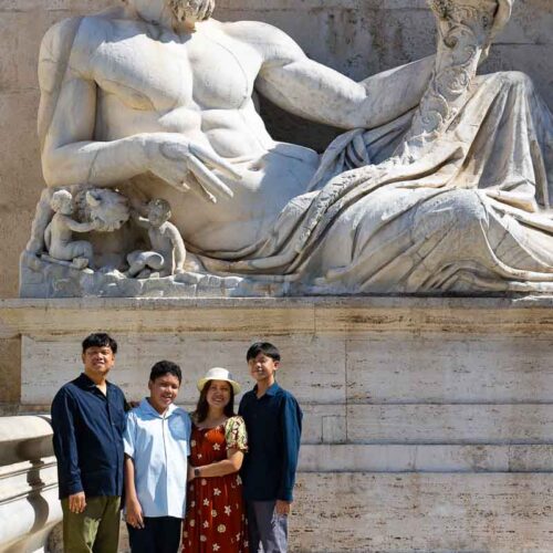 Posed family picture underneath an ancient Roman Marble Statue
