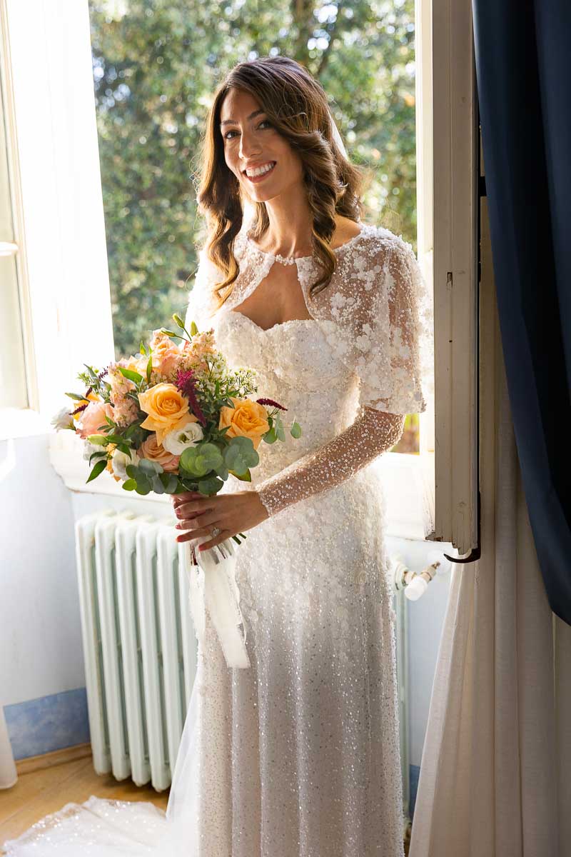 Bridal portrait standing by the widow light during bride preparation