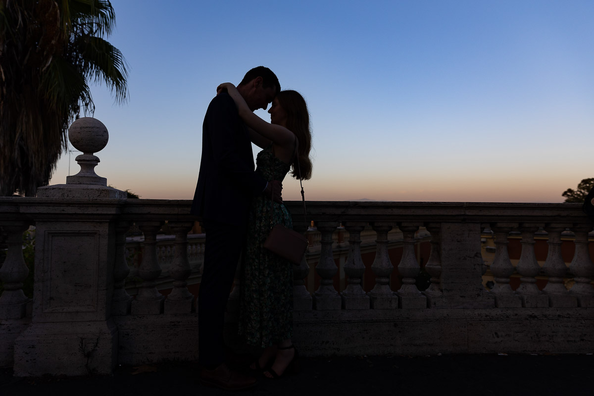 Silhouette picture of a couple kissing at dusk overlooking Rome 