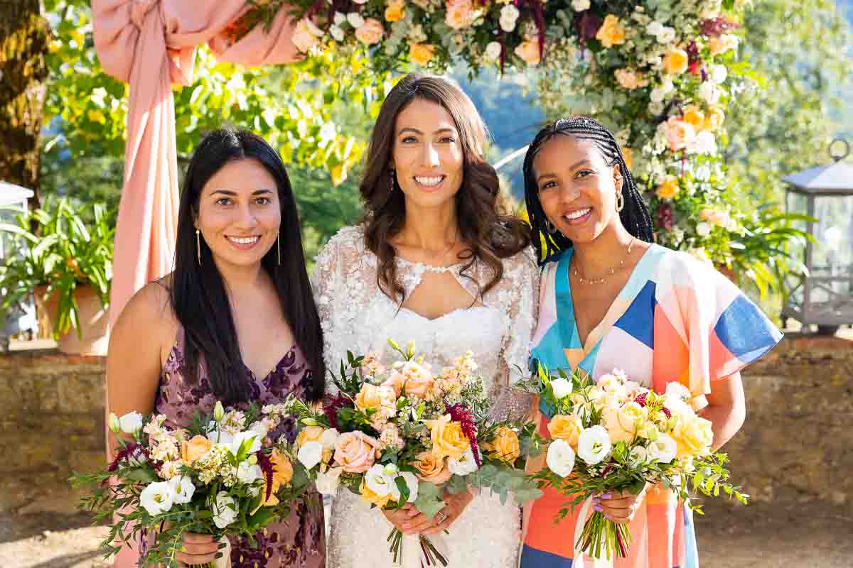 Bridesmaids portrait with the bride photographed in front of the arch of flowers
