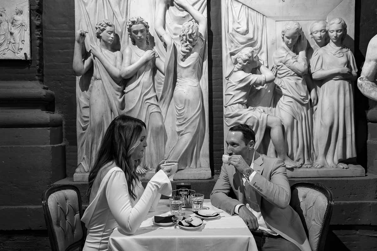 Drinking an Italian espresso coffee together under nice marble sculptures. Couple in Rome PhotoShoot