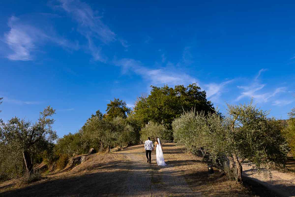Walking up the hill holdings hands. Tuscany wedding photography 