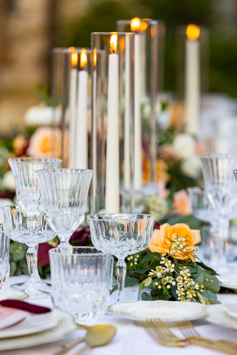 Close up of the wedding decorated table with glasses and lit candles