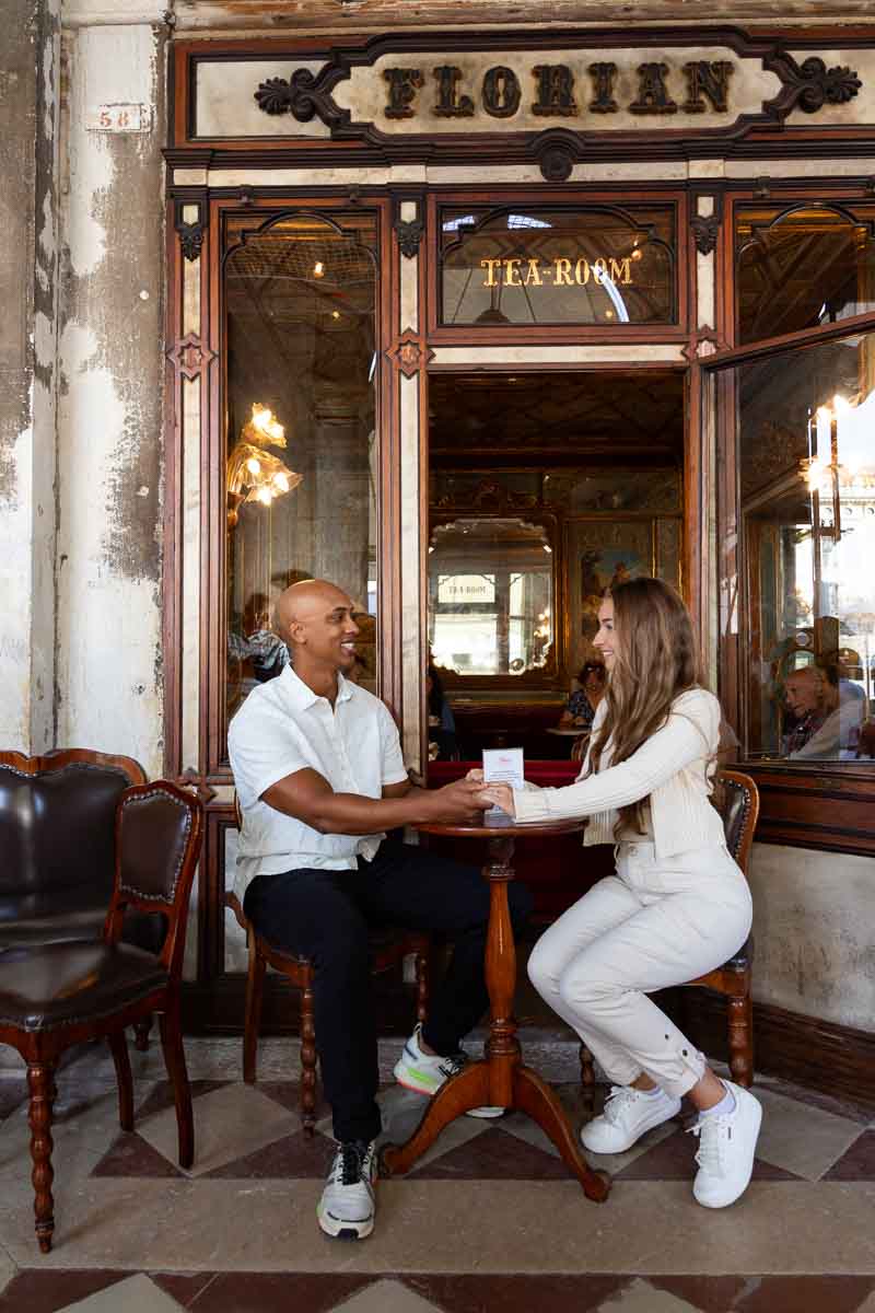 Sitting down together at the Florian Cafè in Venice during an engagement photo shoot 