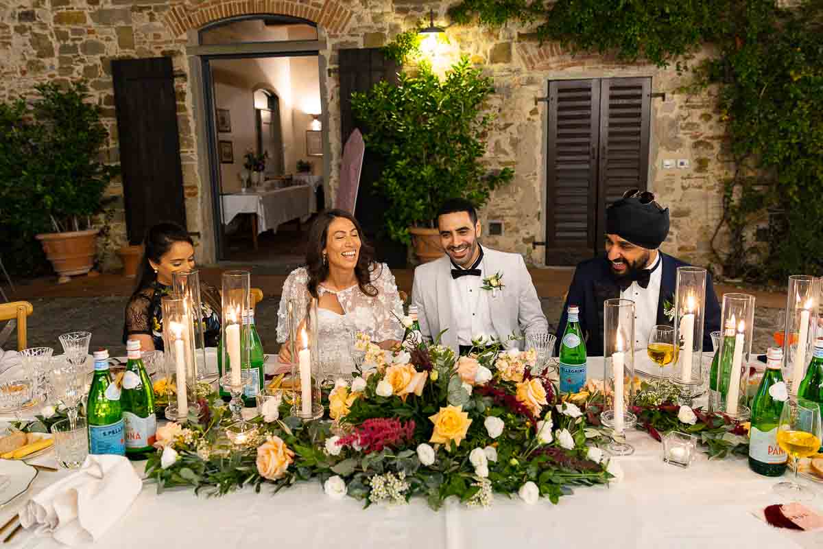 The groom and the bride sitting down at their table for dinner